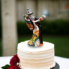 a wedding cake with a colorful figurine on top