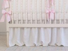 a white crib with pink bows on it