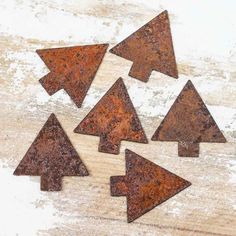 rusted metal christmas trees sitting on top of a wooden table