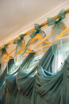 some green and yellow ribbons hanging from the ceiling in front of a window with windowsills