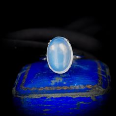 This magical Art Deco Moonstone ring features an iridescent 5.20ct Cabochon Ceylon Moonstone gemstone modelled in 18ct White Gold. The colour of the Moonstone boasts a silvery blue adularescence, making this a highly collectable find.  As ancient as the moon itself, Moonstone holds the power of mystery. Named for its moon-like sheen, Moonstone calms and encourages, teaching us the natural rhythms of life. This vintage ring would make the perfect gift or a great addition to any collection.  STON Silvery Blue, Magical Art, Etsy Gold Ring, Professional Jewelry, Ring Art Deco, White Gold Band, White Gold Ring, Moonstone Ring, Vintage Ring