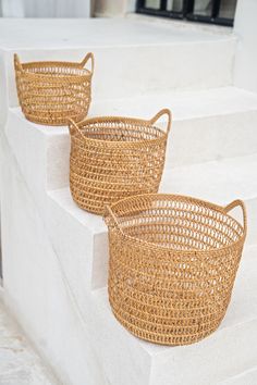 three woven baskets sitting on the side of some steps