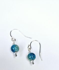 Handcrafted Teal Cracked Glass Earrings are the perfect earrings for any occasion. Pairs well with any casual outfit and makes a great gift for family and friends. Dress up or down for any event. Perfect for a wedding. SHIPPING:  PROCESSING TIME IS CURRENTLY 1-2 DAYS FROM THE DATE OF PURCHASE. Processing time does not include shipping which is an extra 3-5 days. You will receive an email with tracking information once your order ships. Orders are processed Monday through Saturday. The earrings pictured are made from high-quality faux pearls.  The earring hooks are made of high-quality material. They are nickel-free,hypo-allergenic, safe and durable. The earring backs are made of silicone, they are pliable and comfortable to wear. This item was created in a smoke-free environment. Thank you Friends Dress, Ball Earrings, Jewelry Sterling Silver, Earring Hooks, Glass Earrings, Gift For Family, Earrings Dangle, Earring Backs, Glass Jewelry