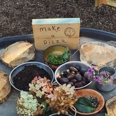 there are many different types of plants in bowls on the table with a sign that says make a pizza