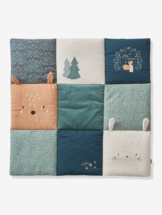 a blanket with animals and trees on it