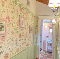 the hallway is decorated in pastel colors with pink and green flowers on the wall