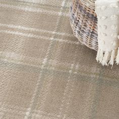 a basket sitting on top of a carpet next to a white and brown rug with fringes