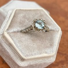 Estate/ Vintage 14KT white gold ring with genuine, rounded, square, cushion-cut aquamarine + diamond halo and accents. Pale, blue color aquamarine with yellow/green undertones. Beautiful stone + well faceted. Size 7 Weight: 3.2 grams Genuine, rounded square cushion cut Aquamarine measures: 6mm x 6mm 1.00+ carat genuine aquamarine .30 CT natural diamonds; SI1/2 clarity (22) diamonds on the shank (12) diamonds on the scroll, filigree halo Not stamped 14K, but fully tested Gold is patina'd and we l Wedding Diamond Ring With Aquamarine Halo Setting, Aquamarine Wedding Diamond Ring With Halo Setting, Luxury Light Blue Rings With Accent Stones, Fine Jewelry Aquamarine Diamond Ring With Center Stone, Elegant Aquamarine Ring With Ethical Diamonds, Light Blue Aquamarine Ring With Diamond Accents, Heirloom Aquamarine Jewelry With Center Stone, Light Blue Diamond Jewelry With Accent Stones, Fine Aquamarine Diamond Ring With Accent Stones