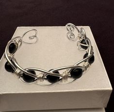 Handmade Hypoallergenic Aluminum Wire Wrapped Obsidian Bead Bracelet. Obsidian (Root Chakra). A Strongly Protective stone, known for its ability to Block, Absorb, and Transform negative energy. Truth-enhancing, Brings clarity to the mind and Clears confusion. Promotes qualities of compassion, strength and increases self-control. Aluminum symbolizes flexibility and versatility due to its malleable nature. This light weight metal will never tarnish or discolor. It is also hypoallergenic.and does not cause skin allergies. Makes a wonderful Valentine's Day Gift, Mother's Day Gift, or maybe even a Gift for yourself! Gift for any occasion, JUST BECAUSE - GIFTS OF LOVE! CARE INSTRUCTIONS: I recommend not wearing while exercising, showering or swimming. Use warm soapy water to clean then dry with Nickel-free Modern Beaded Bracelets As Gift, Modern Nickel-free Beaded Bracelets For Gifts, Handmade Black Crystal Bracelet As Gift, Handmade Black Crystal Bracelet Gift, Modern Hand Wrapped Bracelets As Gift, Adjustable Onyx Bracelet Gift, Adjustable Crystal Bracelet With Black Beads As Gift, Spiritual Black Cuff Bracelet For Gift, Black Spiritual Cuff Bracelet As Gift