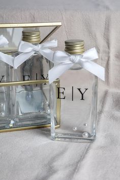 two small bottles with white ribbons tied around them