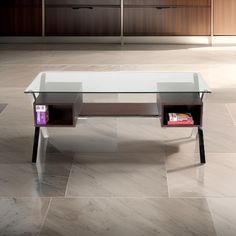 a glass table sitting on top of a tile floor next to a book shelf and cabinets