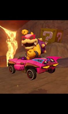 mario kart is riding on top of a pink car with flames in the background