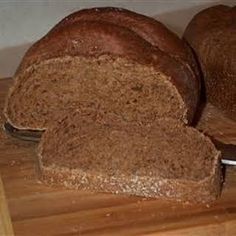 two loaves of bread sitting on top of a wooden cutting board