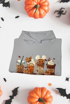 a gray shirt with pumpkins and bats around it, on top of a white surface