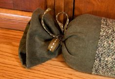 a green bag sitting on top of a wooden floor next to a pair of scissors