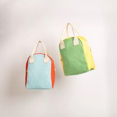 two handbags hanging on the wall, one in different colors