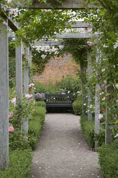 a black bench sitting in the middle of a garden