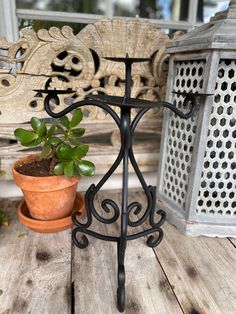 a potted plant sitting on top of a wooden table next to a metal stand