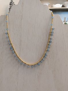 This dainty necklace is made with blue quartz beads and tiny gold seed beads. It is approximately 15" in length. Delicate Gold Beaded Crystal Necklaces, Delicate Gold Beaded Crystal Necklace, Blue Beaded Dainty Necklace, Adjustable Light Blue Necklaces With Tiny Beads, Dainty Blue Beaded Necklace, Dainty Gold Crystal Necklace With Tiny Beads, Adjustable Gold Crystal Necklace With Dangling Beads, Delicate Gold Beaded Necklaces With Gemstones, Dainty Blue Beaded Necklace With Faceted Beads