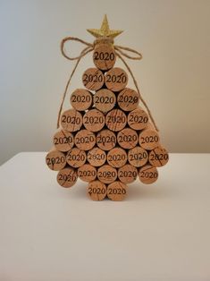 a christmas tree made out of wine corks with the numbers on it and a gold star