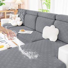 a person pouring water onto a couch in a living room with other furniture and decor