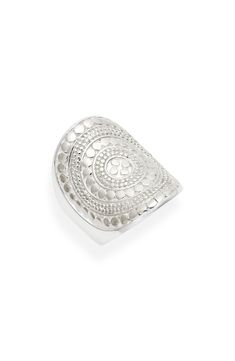 a silver ring with an intricate design on the front and center, set against a white background