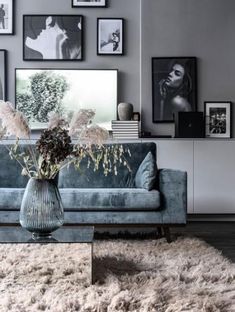 a living room filled with furniture and pictures on the wall