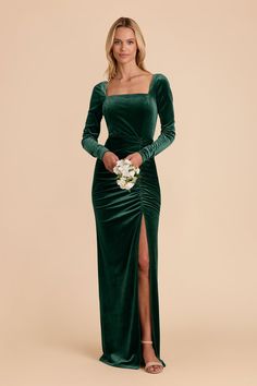 a woman wearing a green velvet dress with long sleeves and thigh slits, holding a bouquet