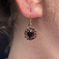 Prized for their striking cherry wine color and distinct inner glow, the now-extinct Bohemian garnet make for a rare antique find. These eye-catching statement earrings are a stunning example of Victorian-era craftsmanship that perfectly showcase the natural beauty of these bewitching gemstones. Handcrafted in the Victorian era Drop-style earrings each approx. 13mm in diameter feature 12 Bohemian garnets approx. 2mm Center oval garnets measure approx. 8 x 6mm Set on new 14k ear wires Because we do all our restoration work by hand we can offer a huge array of customization! If you have inquiries about sizing, alterations, or engraving, you can inquire about a quote here. As with all antiques, this piece is one-of-a-kind and can sell at any time. Antique Mens Jewelry, Cherry Wine, Inner Glow, Wine Color, Wine Colored, Engagement Ring Wedding Band, Style Earrings, Men's Rings, Accessories Bracelets