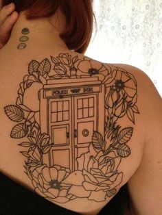 the back of a woman's shoulder with flowers and a phone booth on it