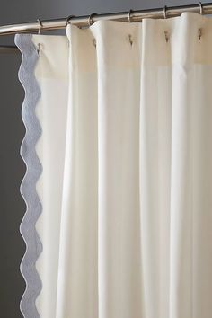 a white curtain hanging on the side of a window