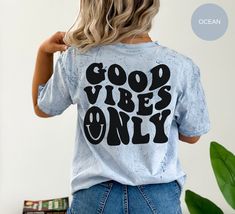 "This \"Good Vibes Only\" Tee is just what you need to add some fun and whim into your wardrobe! Crafted with super soft, lightweight fabric and dyed in a stunning tie-dye pattern, this shirt will have you looking stylish and feeling comfortable all day long. The vibrant colors are sure to give your wardrobe a much needed boost and make sure you stand out from the crowd. To top it off, this Good Vibes Only Shirt features a super cute smiley face on the front and 'Good Vibes Only' on the back - p Acid Wash Slogan Top With Relaxed Fit, Acid Wash Relaxed Fit Slogan Top, Relaxed Fit Acid Wash Slogan Top, Relaxed Fit Acid Wash Top With Slogan, Fun Acid Wash Tops With Letter Print, Trendy Blue Top With Funny Text, Fun Slogan Shirt With Relaxed Fit, Relaxed Fit Fun Slogan Shirt, Fun Relaxed Fit Slogan Shirt