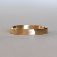 a close up of a gold ring on a white surface with no one around it