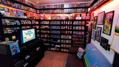 a room filled with lots of games and video game consoles on shelves next to each other