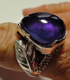 "Amethyst ring with a large pear shaped purple amethyst cabochon gemstone, set in a sterling silver leaf design ring, in a size 6 This vintage ring features a large royal purple amethyst pear amethyst cabochon, set in a solid sterling ring, with a beautiful large leaf embellishment on each side. The ring is a size 6. The polished bezel setting shows off the large, clear and very high quality genuine 16mm x 12mm amethyst jewel. It is stamped \"925\" for solid sterling inside the band. The ring ha Luxury Purple Amethyst Cabochon Ring, Luxury Purple Cabochon Amethyst Ring, Luxury Purple Amethyst Oval Cabochon Ring, Purple Amethyst Oval Cabochon Ring, Formal Amethyst Pear-shaped Ring, Purple Teardrop Amethyst Ring For Anniversary, Elegant Teardrop Amethyst Ring, Formal Purple Cabochon Amethyst Ring, Formal Purple Cabochon Gemstones