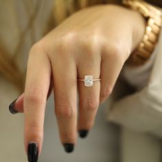 a woman's hand with a diamond ring on it