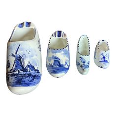 three pieces of blue and white pottery with windmills painted on the front, side, and back