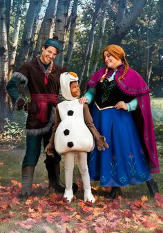 a man and woman in costume standing next to a child dressed as a snowman