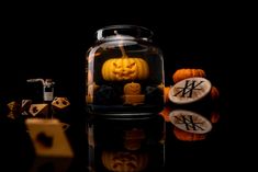 a glass jar filled with carved pumpkins and jack - o'- lantern candles