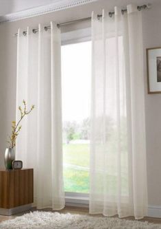 a living room with white curtains and rugs