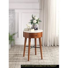 a small table with flowers on it in front of a white wall and window sill