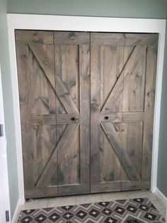 two wooden doors are open on the wall in front of a black and white rug