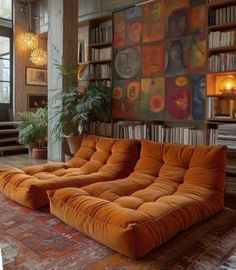 an orange couch sitting on top of a rug in front of a bookshelf