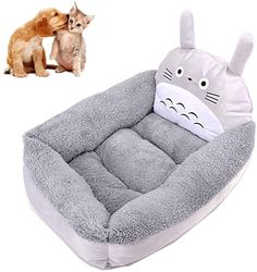 a dog bed with a totoro pillow on top and a cat sitting next to it