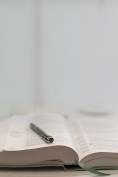 an open book with a pen sitting on top of it