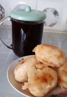 some fried food on a plate next to a cup