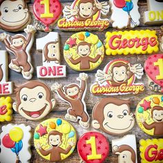 decorated cookies with monkey faces and numbers for 1st birthdays are displayed on a table