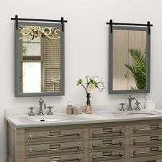 two bathroom sinks with mirrors above them and flowers in vases on the counter top