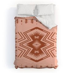 an orange and white comforter on top of a bed next to two pillow cases