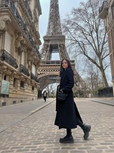 a woman standing in front of the eiffel tower